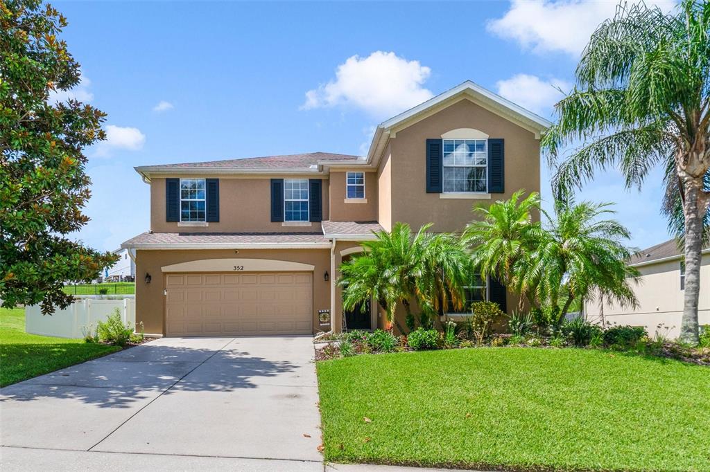 352 Giovani Boulevard Clermont, FL 34715 - Photo 2 of 46 a front view of a house with a yard and garage