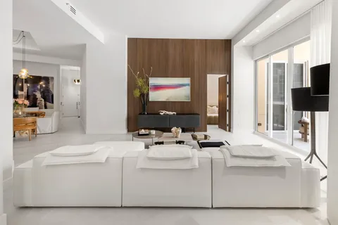 a living room with furniture a flat screen tv and white walls