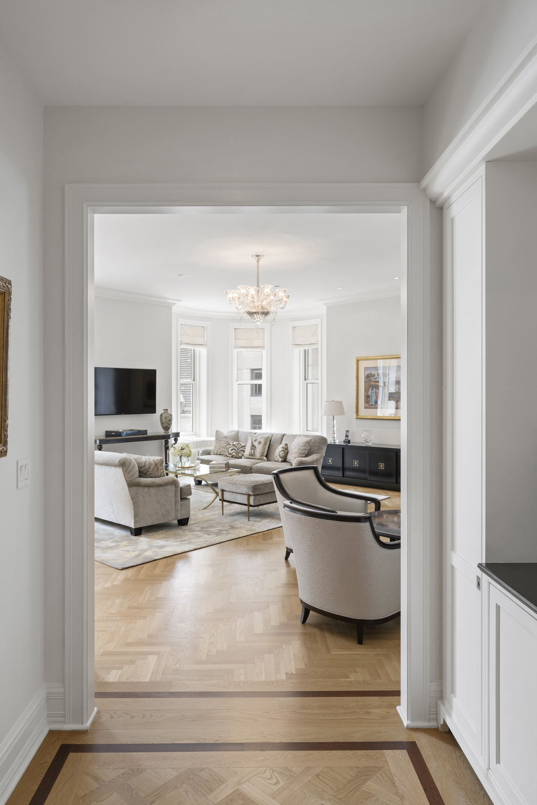 1 Central Park South, Unit 915 Manhattan, NY 10019 - Photo 17 of 29 a living room with a couch and a flat screen tv
