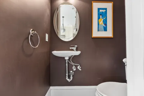 a bathroom with a toilet a sink and a mirror