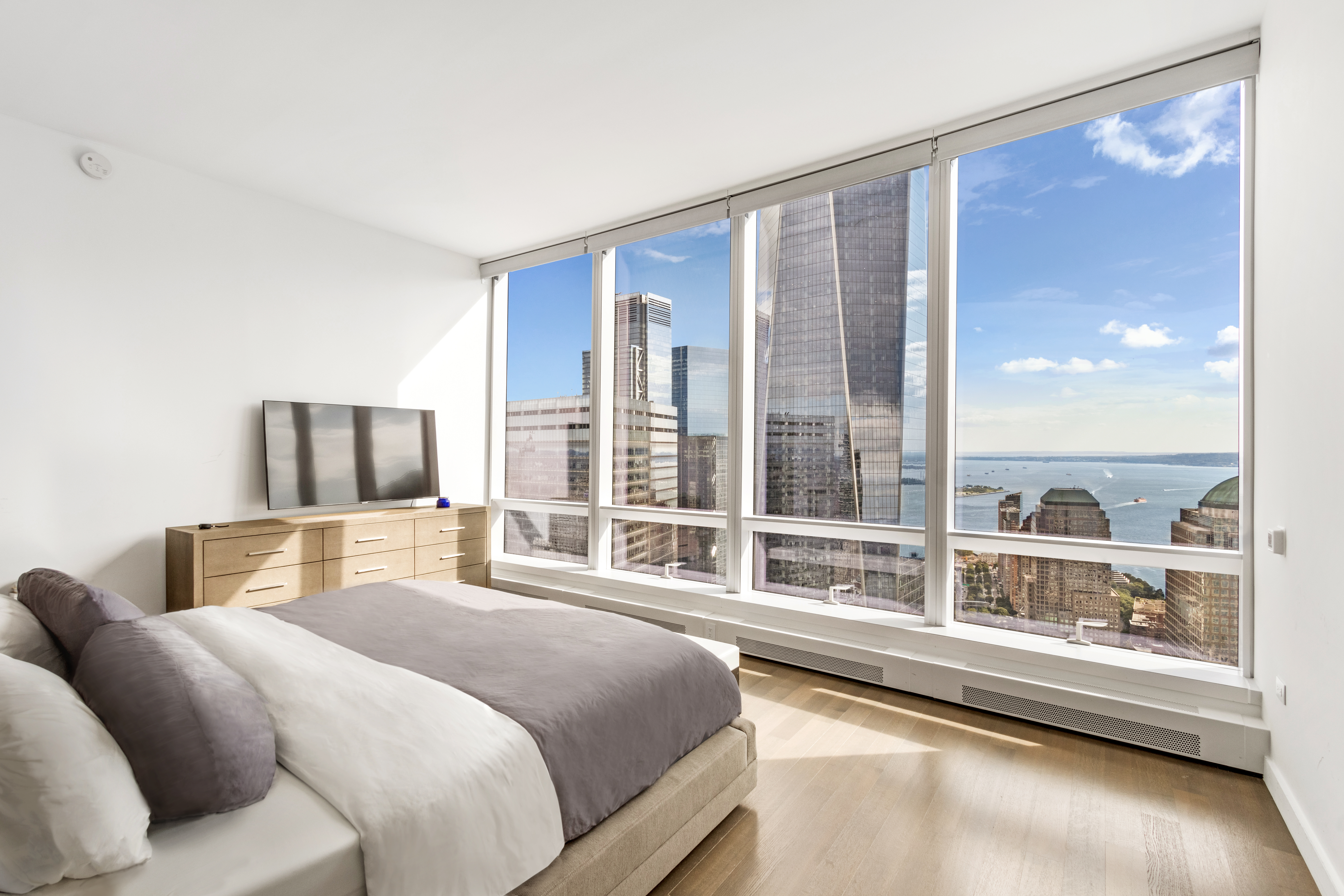 111 Murray Street, Unit 61W Manhattan, NY 10007 - Photo 19 of 35 a bedroom with a large bed and a large window with outer view