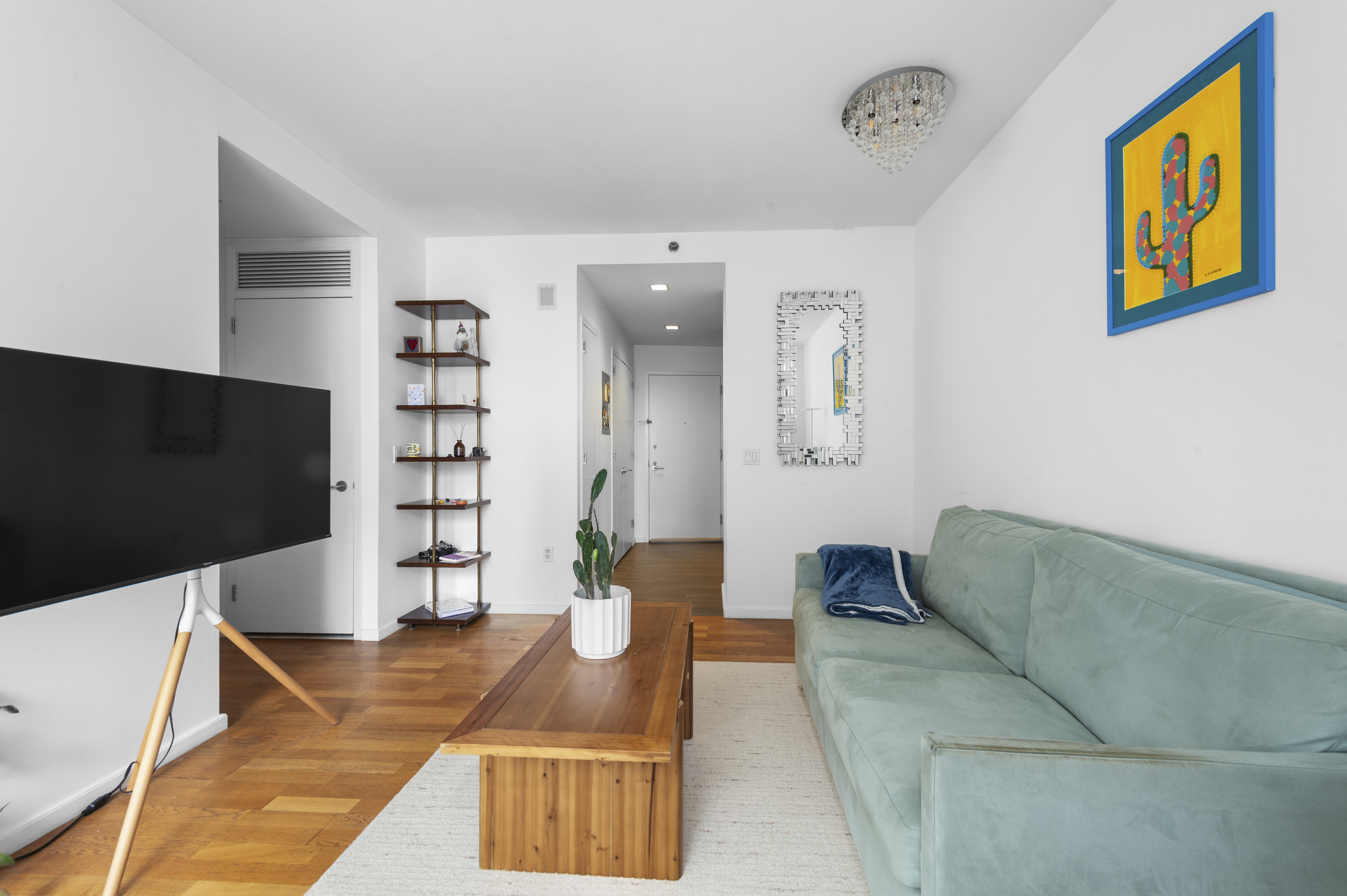 635 West 42nd Street, Unit 14K Manhattan, NY 10036 - Photo 6 of 19 a living room with furniture and a flat screen tv
