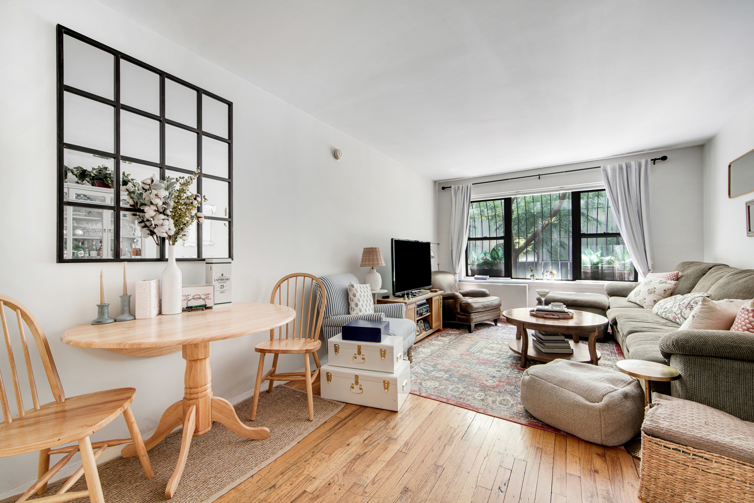 417 East 90th Street, Unit 1G Manhattan, NY 10128 - Photo 2 of 10 a living room with furniture large window and wooden floor