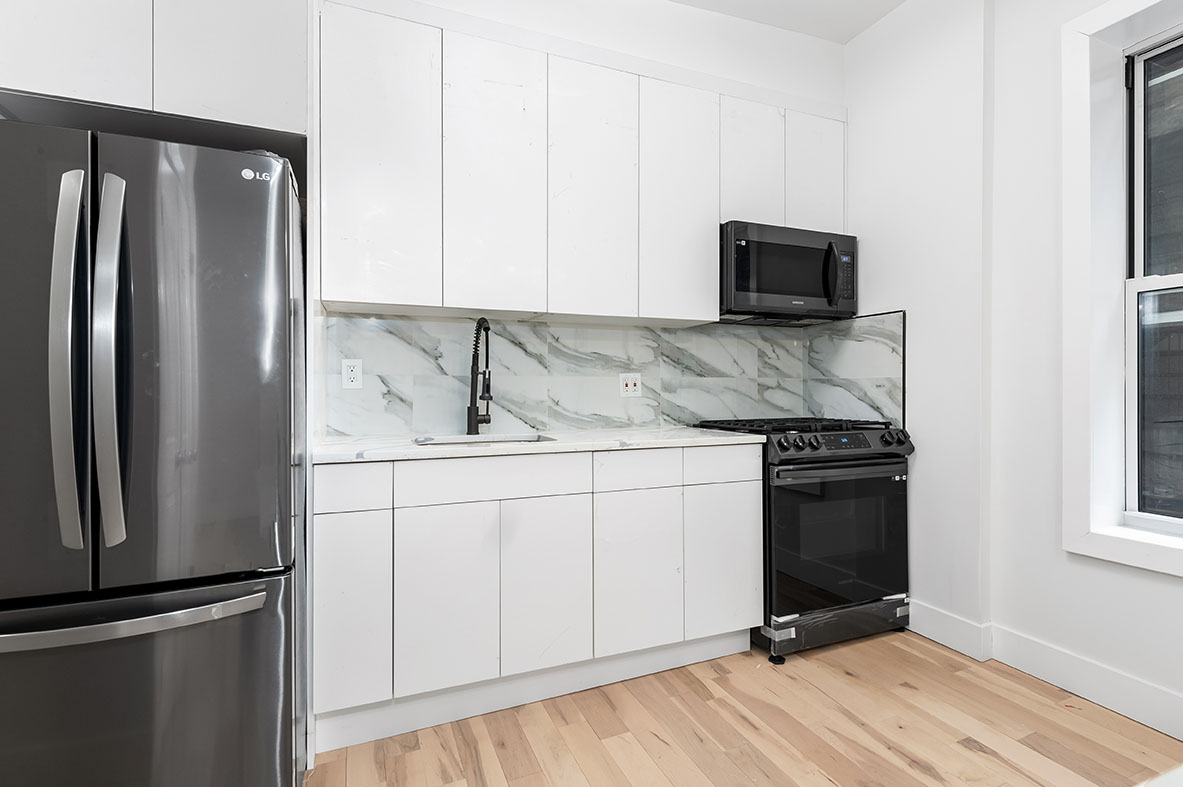 88 Brooklyn Avenue, Unit A3 Brooklyn, NY 11216 - Photo 6 of 12 a kitchen with granite countertop a refrigerator stove and microwave