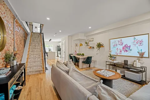 a living room with furniture a flat screen tv and a window
