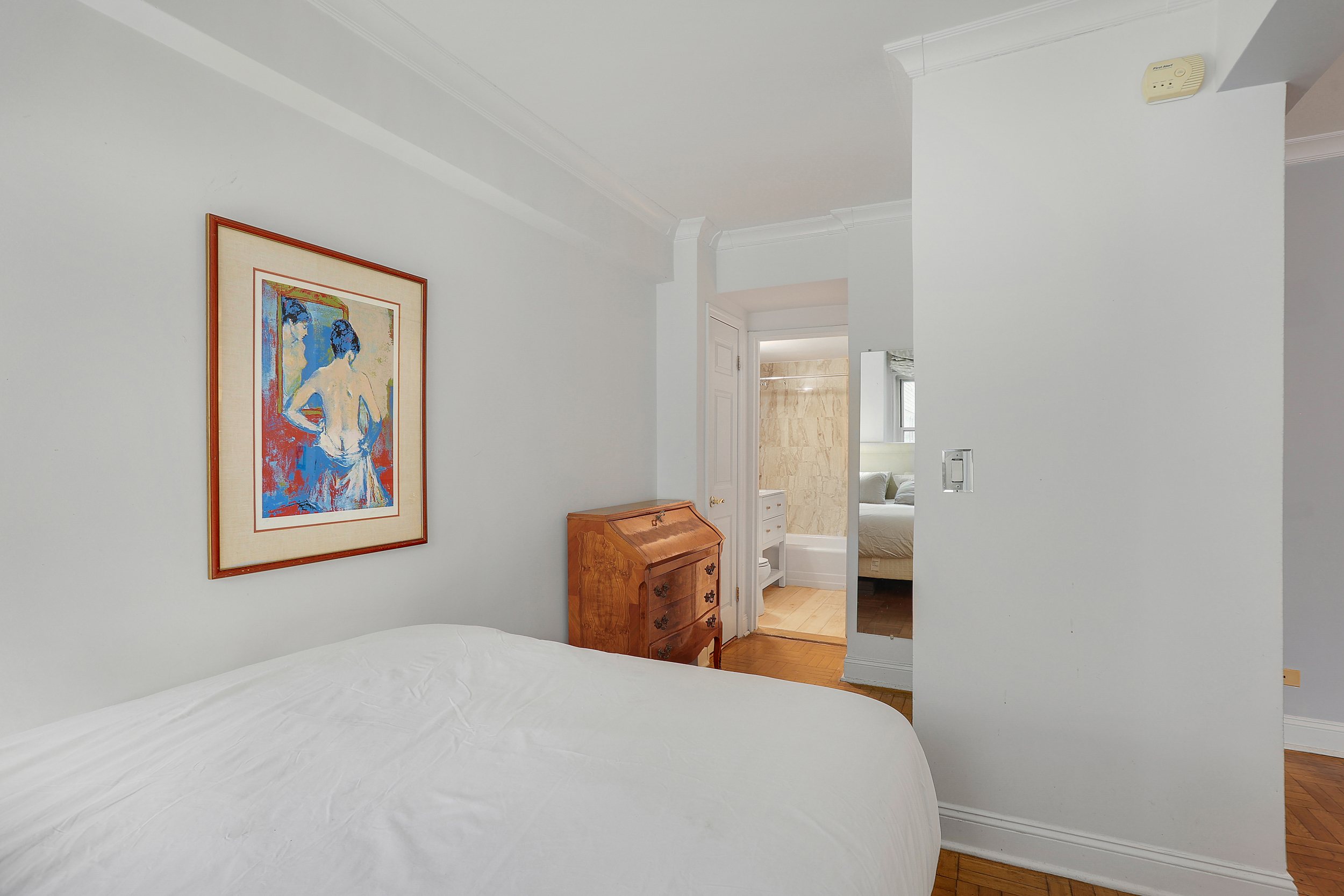 100 West 57th Street, Unit 15N Manhattan, NY 10019 - Photo 6 of 9 a bedroom with a bed and a painting on the wall