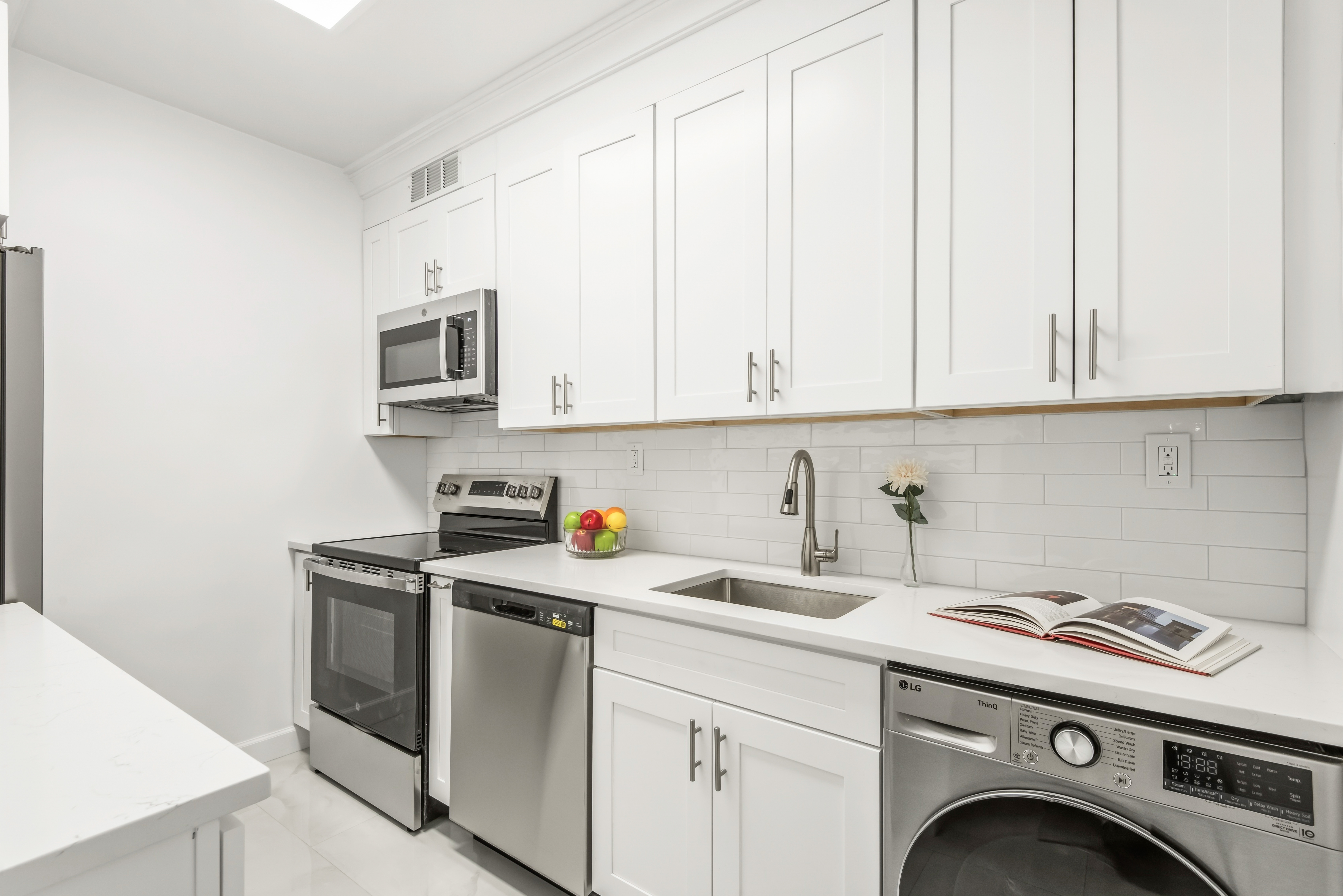 175 East 62nd Street, Unit 14B Manhattan, NY 10065 - Photo 8 of 12 a view of cabinets a washer and dryer
