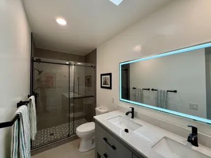 a bathroom with a sink mirror toilet and shower