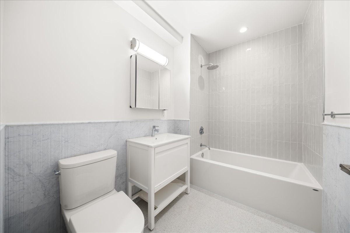463 West 142nd Street, Unit 4B Manhattan, NY 10031 - Photo 6 of 10 a bathroom with a sink a toilet and shower