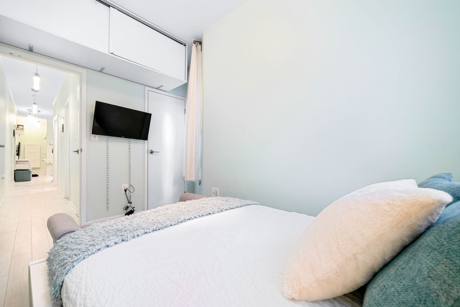 a bedroom with a bed and a flat screen tv