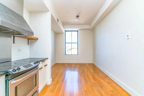 a kitchen with a stove wooden floor and a window