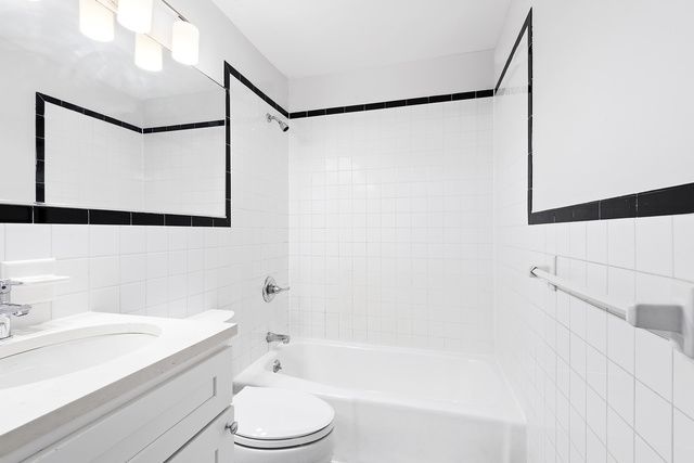 120 Smith Street, Unit 1 Brooklyn, NY 11201 - Photo 8 of 11 a bathroom with a bathtub shower sink vanity and toilet