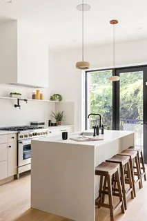 a kitchen with kitchen island a large window a sink and appliances