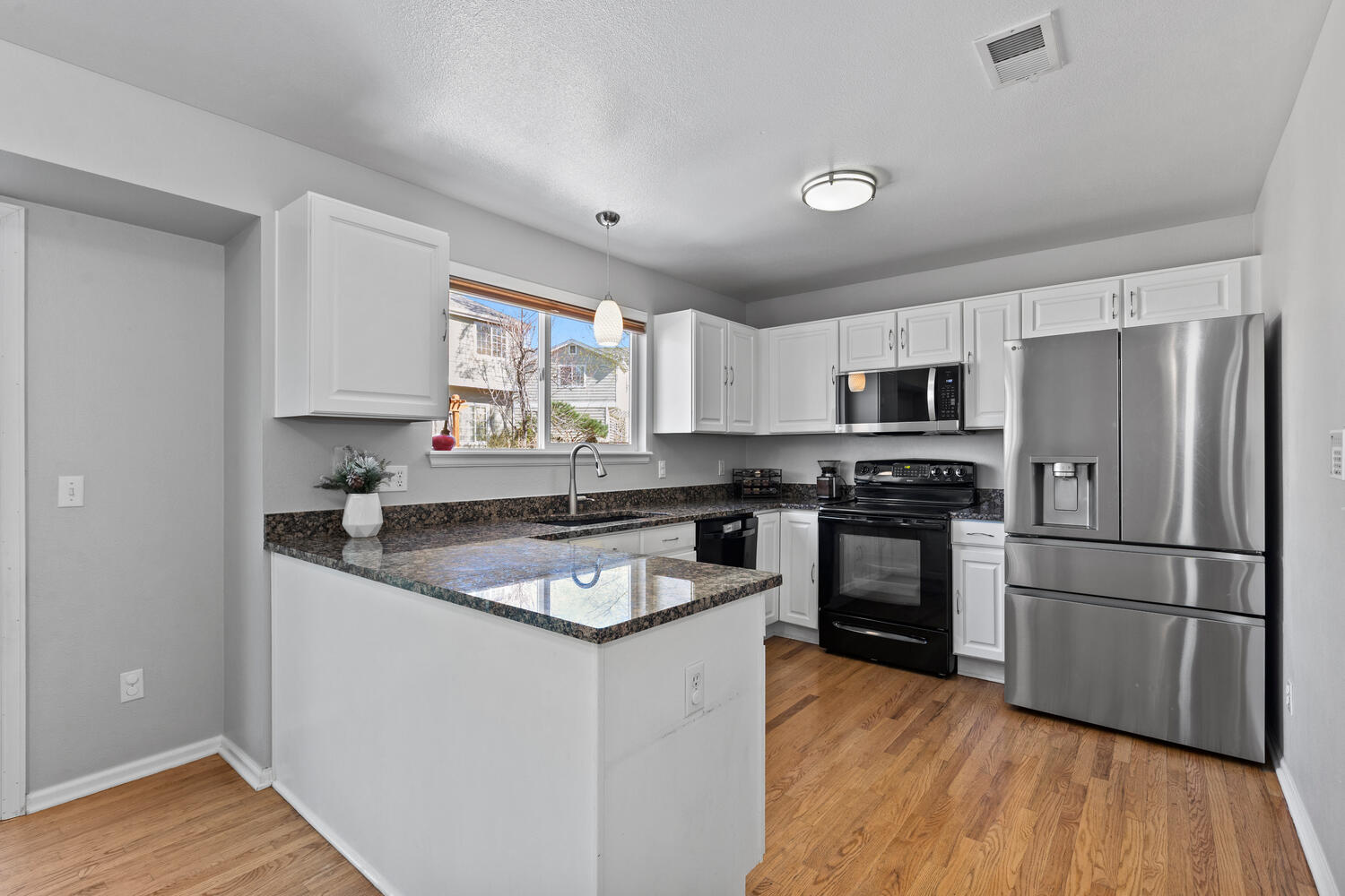 847 Timbervale Trail Highlands Ranch, CO 80129 - Photo 10 of 36 a kitchen with granite countertop stainless steel appliances a refrigerator sink and microwave