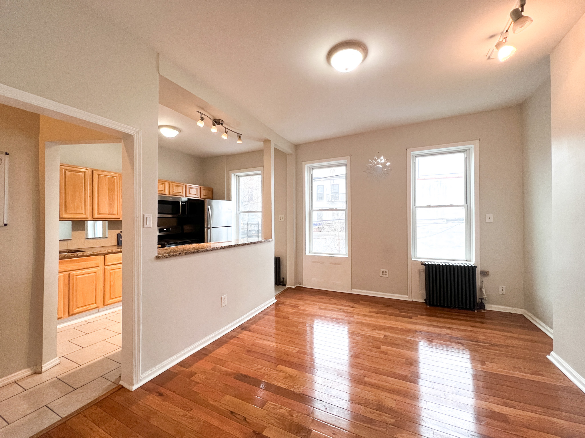 a view of a kitchen with a sink a refrigerator and wooden floor