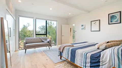 a bedroom with a bed and a large window