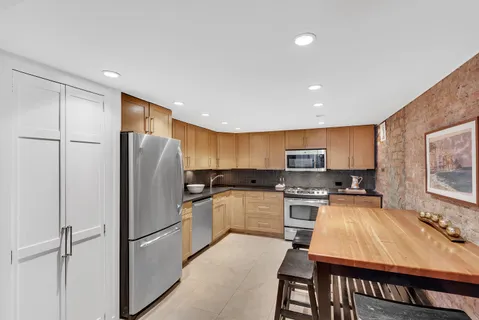 a kitchen with kitchen island a refrigerator stove and microwave