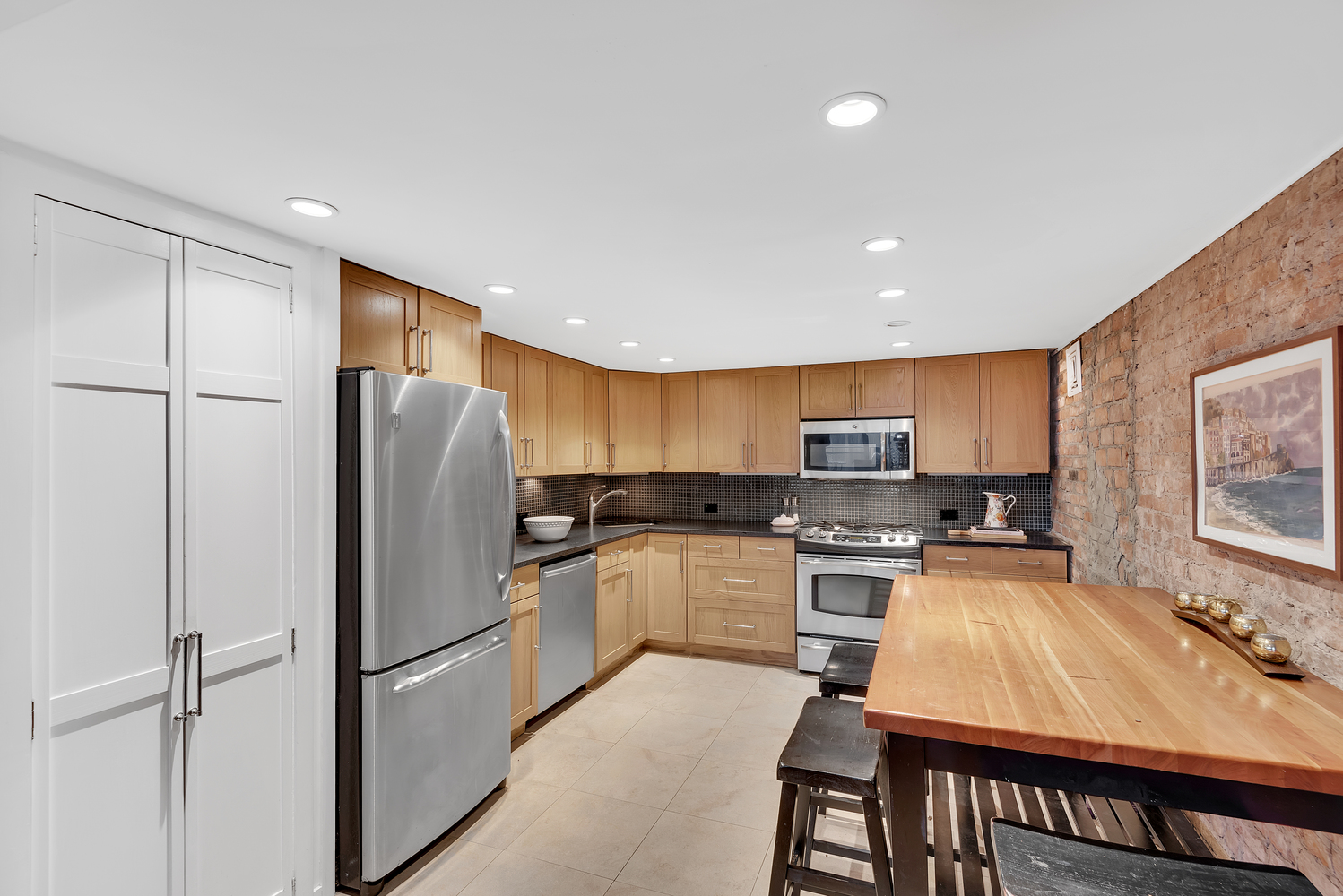 41 East 19th Street, Unit 1B Manhattan, NY 10003 - Photo 4 of 8 a kitchen with kitchen island a refrigerator stove and microwave