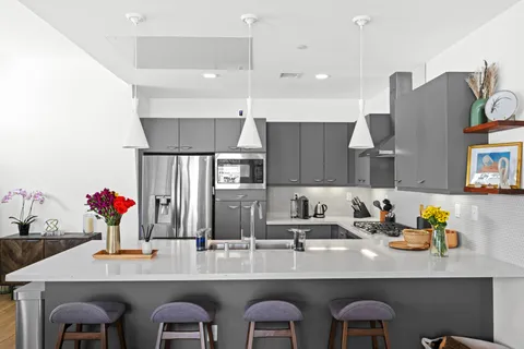 a kitchen with cabinets a sink and chairs