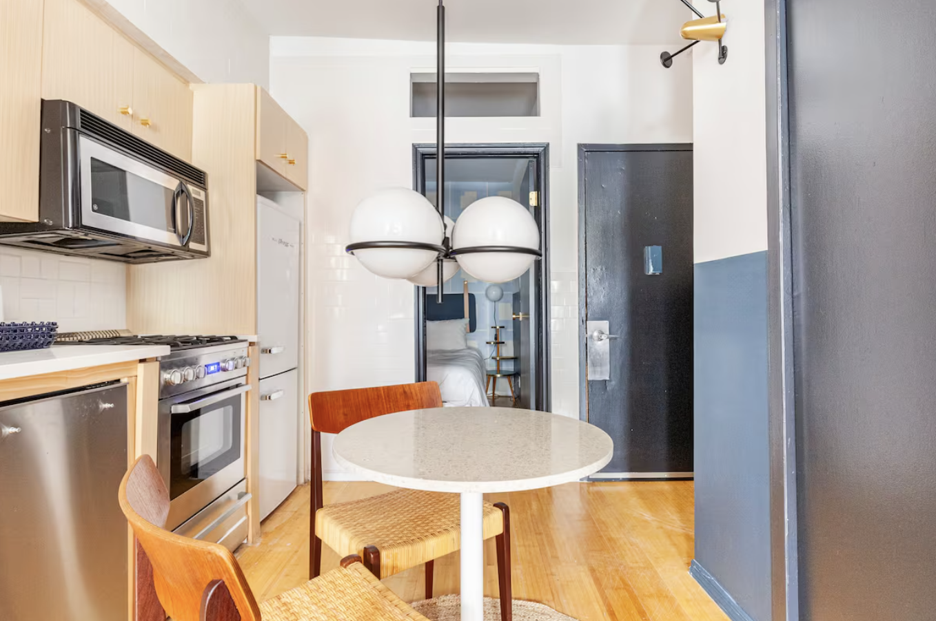 240 Mulberry Street, Unit 2 Manhattan, NY 10012 - Photo 9 of 19 a kitchen with stainless steel appliances granite countertop a refrigerator a stove a microwave oven with white cabinets and wooden floor