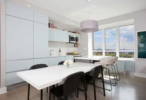 a kitchen with stainless steel appliances a table and chairs in it