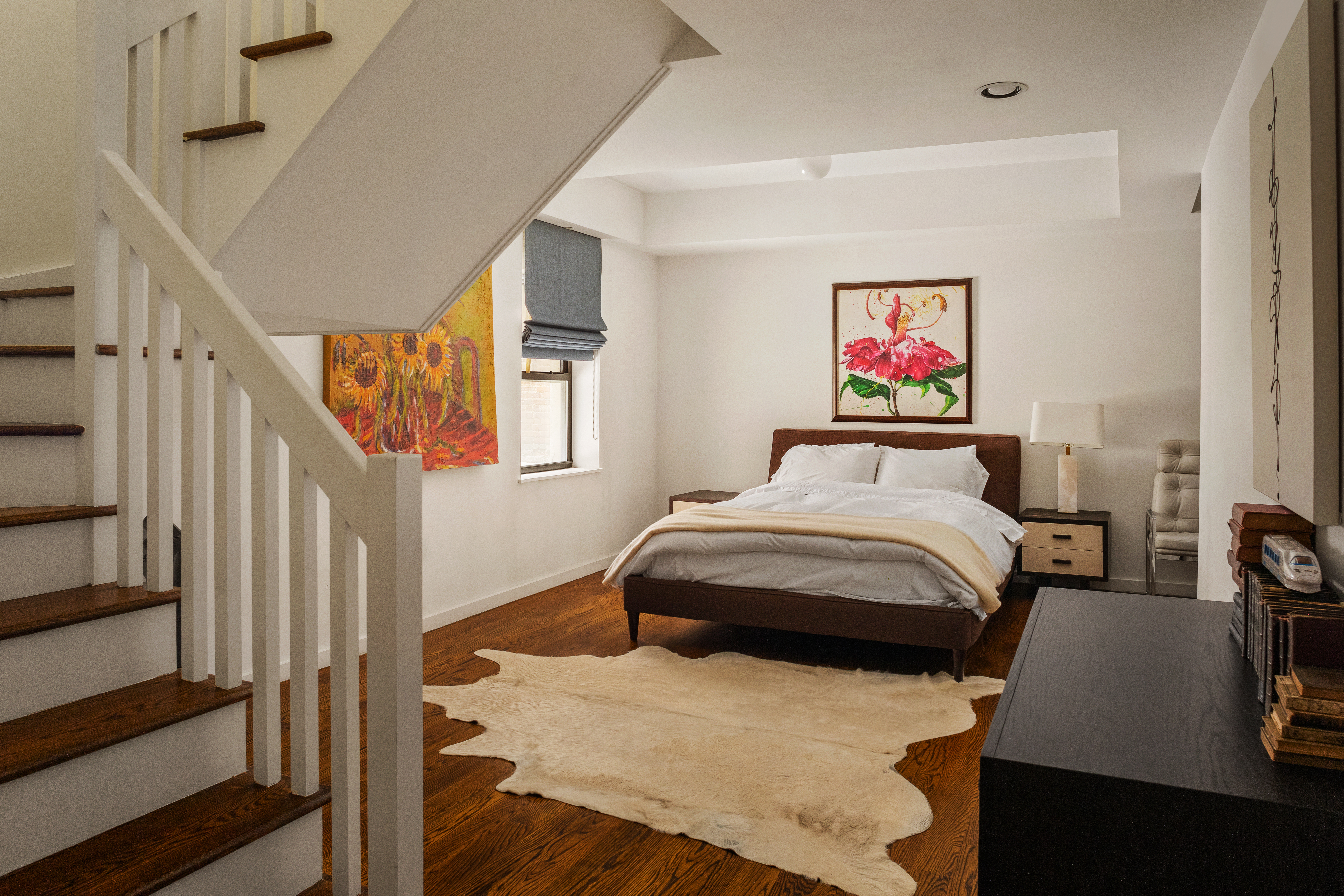 181 Sullivan Street, Unit GARDEN Manhattan, NY 10012 - Photo 8 of 10 a bedroom with a bed and a painting on the wall
