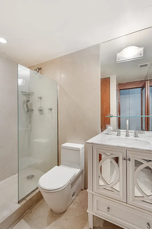 32 East 76th Street, Unit 502 Manhattan, NY 10021 - Photo 5 of 7 a bathroom with a granite countertop toilet a sink and a shower