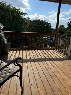 a view of balcony with wooden floor and fence