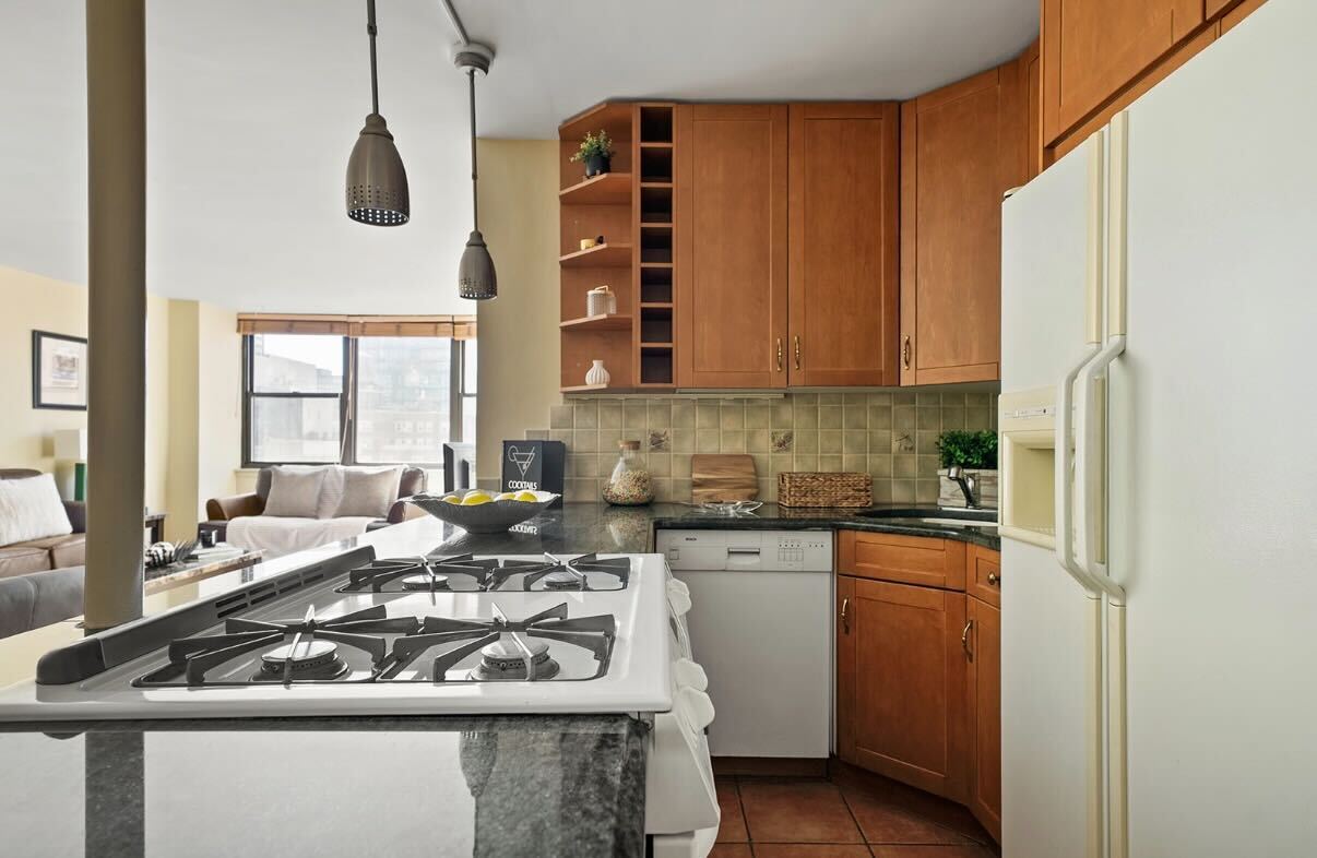 225 East 36th Street, Unit 10N Manhattan, NY 10016 - Photo 5 of 13 a kitchen with a stove a sink and a refrigerator