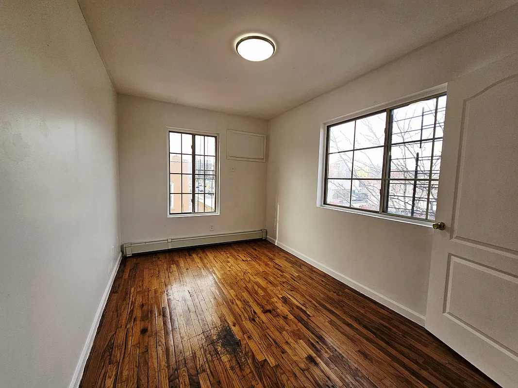 1784 Linden Boulevard, Unit 3 Brooklyn, NY 11207 - Photo 5 of 8 an empty room with wooden floor and windows