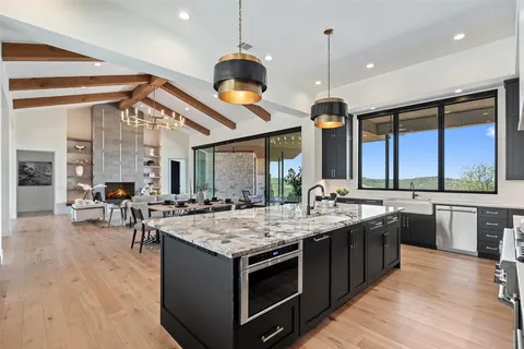 a kitchen with a stove a counter space a sink and dishwasher a oven with wooden floor