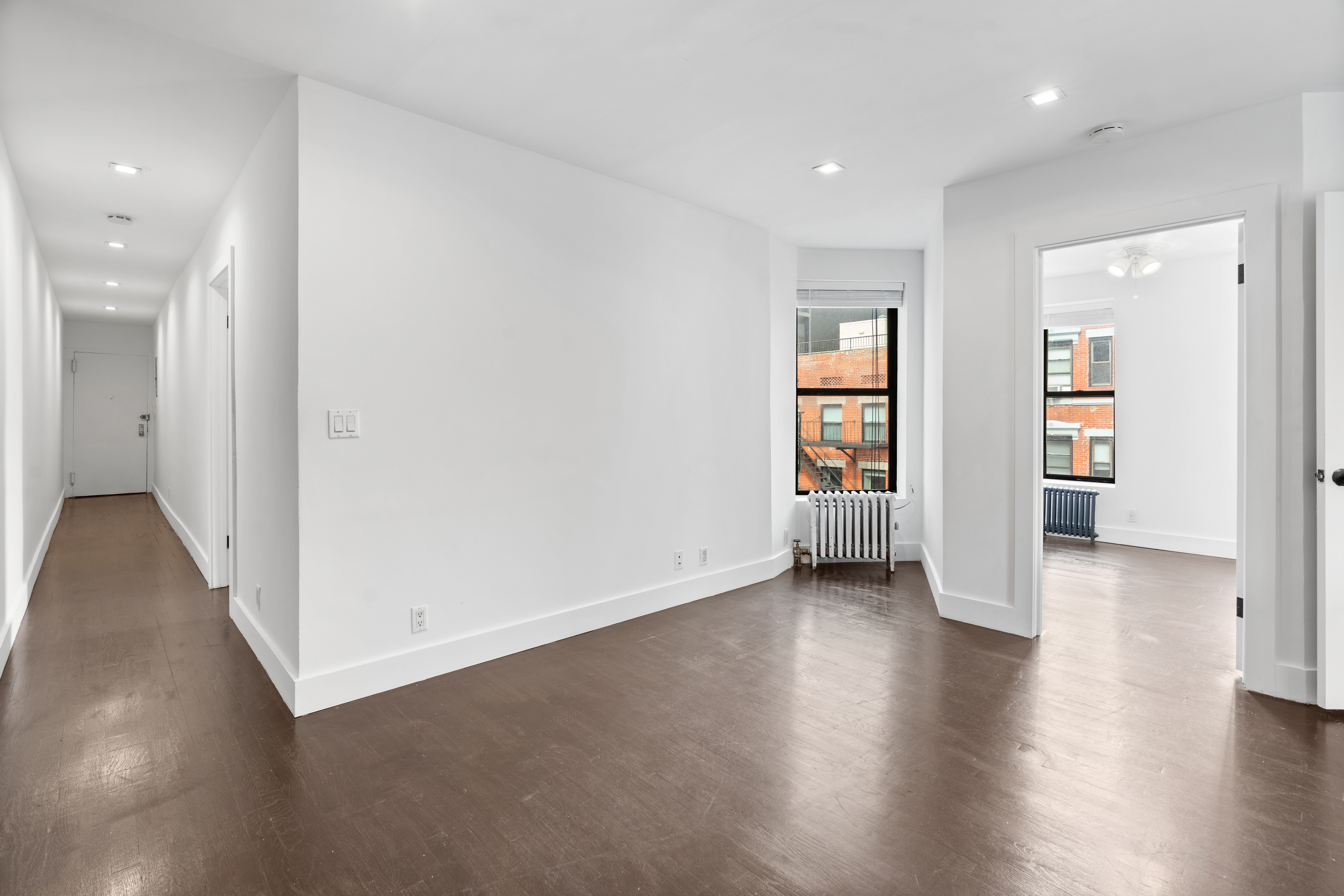 140 Orchard Street, Unit 14 Manhattan, NY 10002 - Photo 4 of 9 an empty room with wooden floor and windows