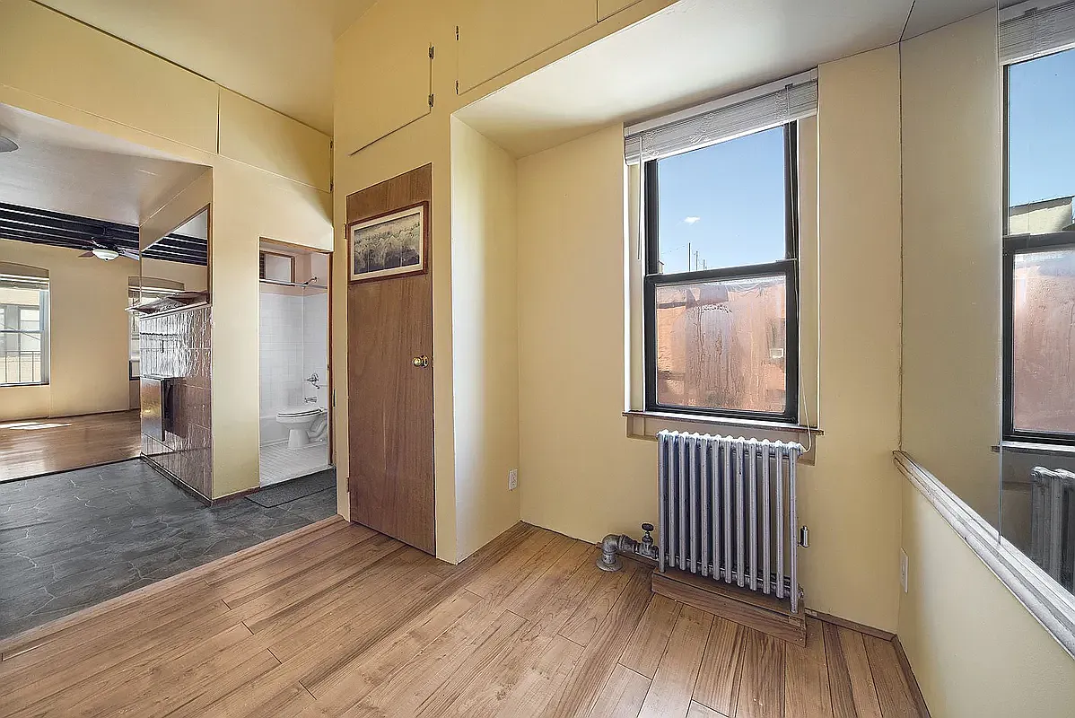 312 West 49th Street, Unit 5RW Manhattan, NY 10019 - Photo 2 of 5 an empty room with wooden floor and windows