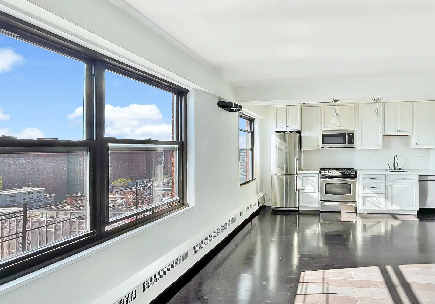 a kitchen with stainless steel appliances granite countertop a refrigerator a stove and a sink with wooden floor