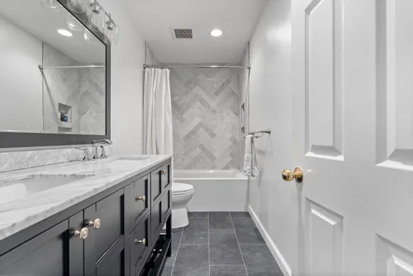 a bathroom with a granite countertop sink toilet and shower