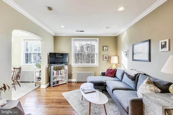 a living room with furniture wooden floor and a large window