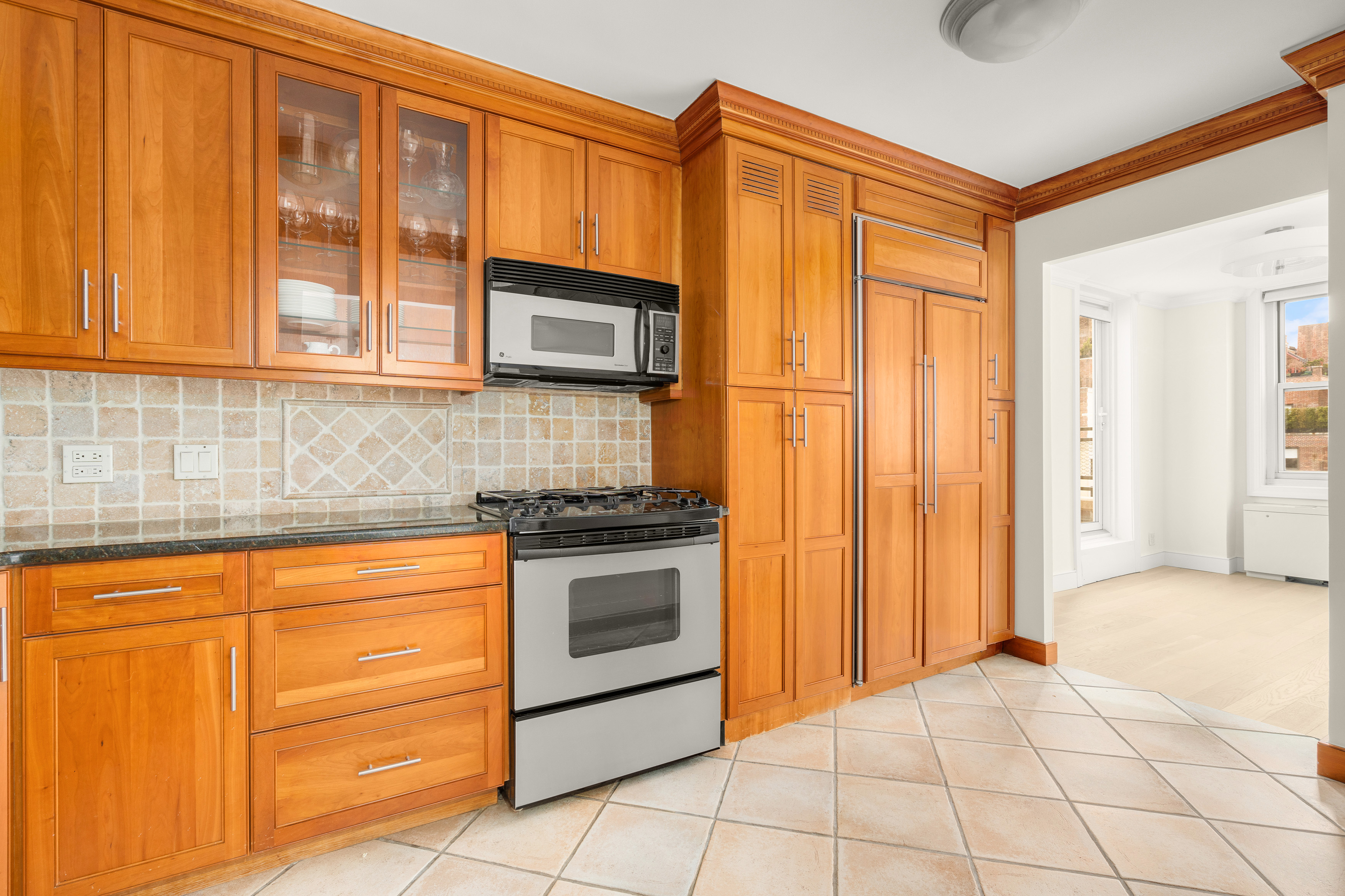 207 East 74th Street, Unit 11E Manhattan, NY 10021 - Photo 8 of 20 a kitchen with stainless steel appliances granite countertop a stove a sink and a microwave