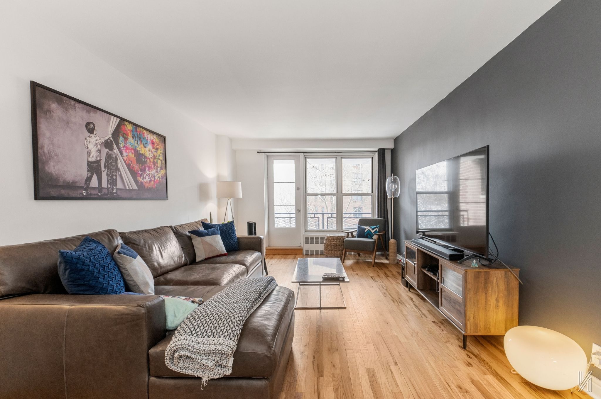 35-50 85th Street, Unit 7H Queens, NY 11372 - Photo 1 of 16 a living room with furniture and a flat screen tv