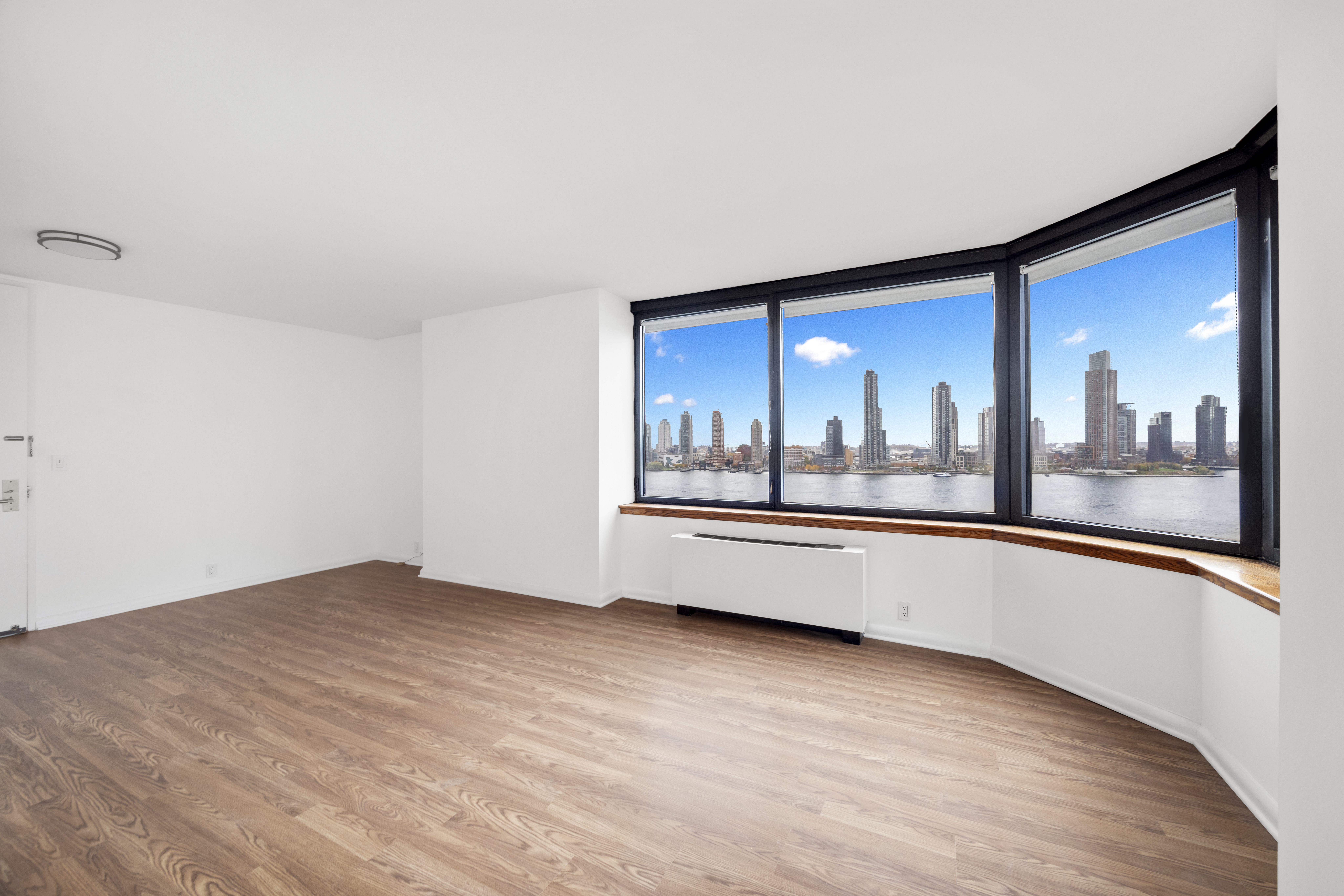 415 East 37th Street, Unit 16F Manhattan, NY 10016 - Photo 3 of 10 a view of an empty room with wooden floor and a window
