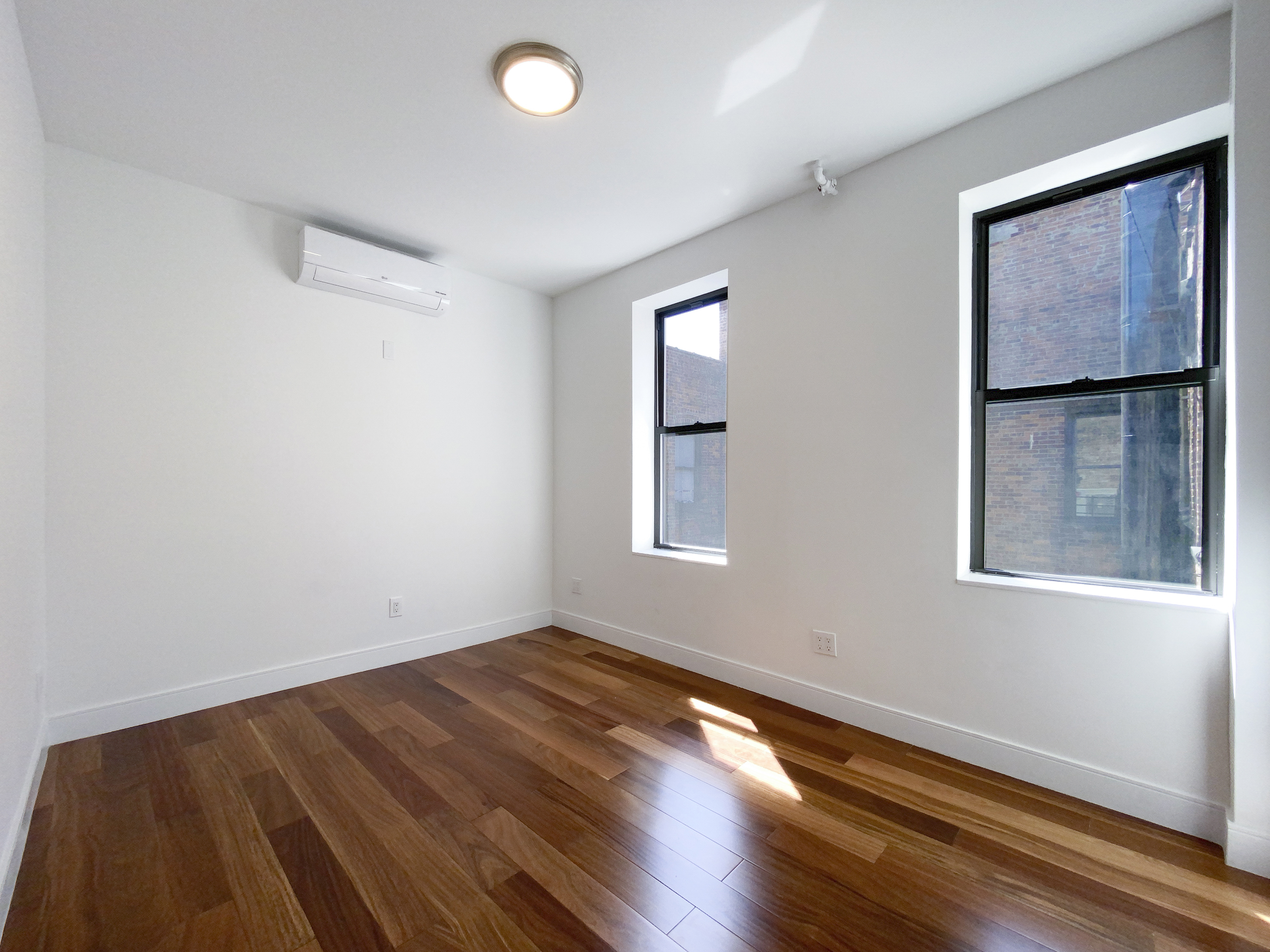 200 West 109th Street, Unit E4 Manhattan, NY 10025 - Photo 10 of 13 an empty room with wooden floor and windows