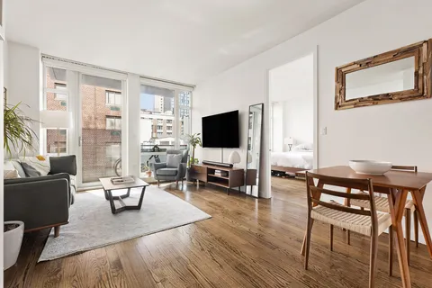 a living room with furniture flat screen tv and large windows