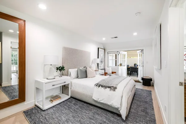 a room with a bed a mirror and lamp