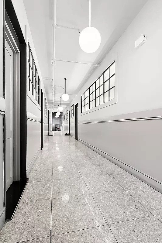 180 Bainbridge Street, Unit 109 Brooklyn, NY 11233 - Photo 12 of 20 a view of staircase with lots of frames on wall and a large window