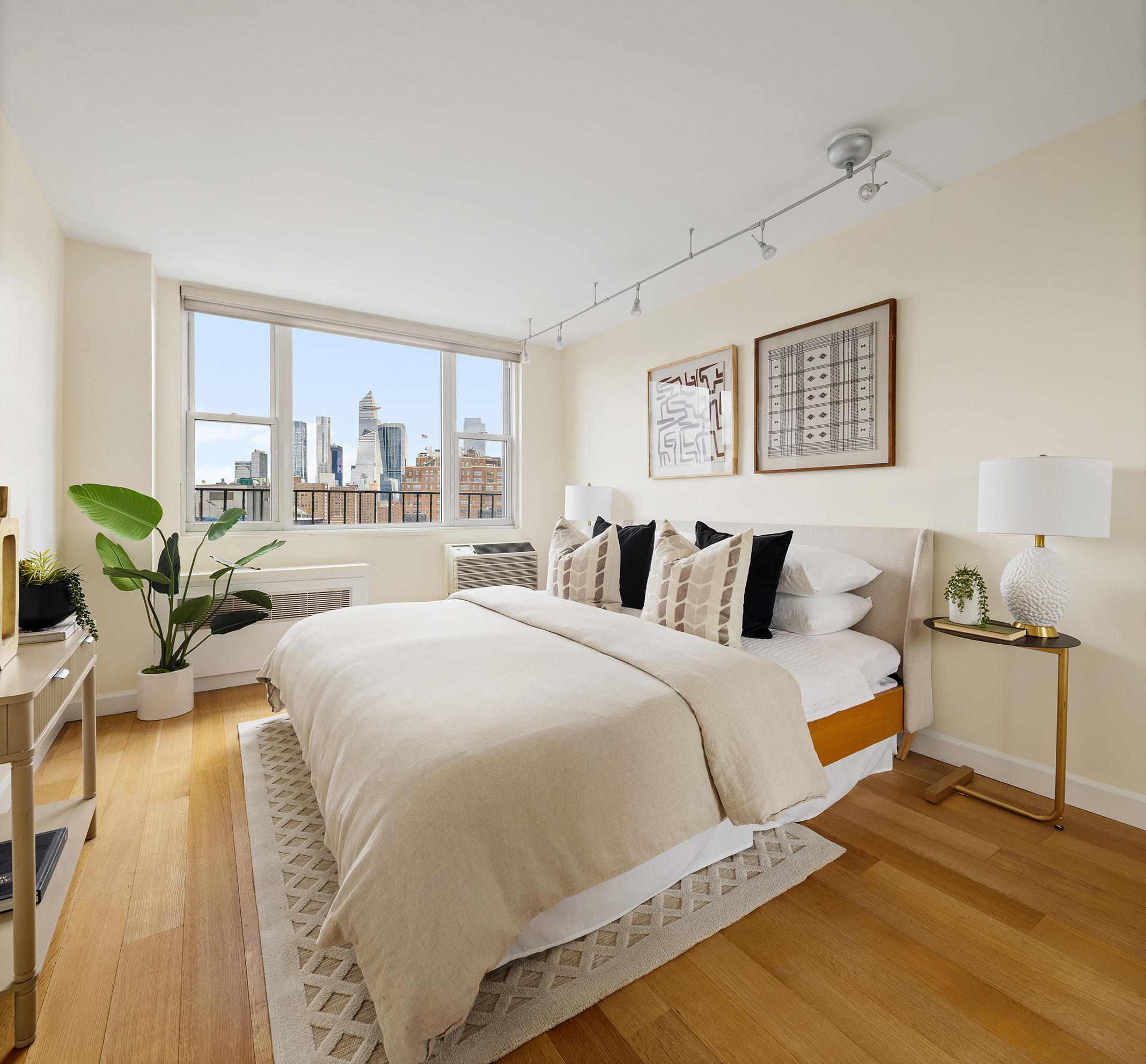61 Jane Street, Unit 19J Manhattan, NY 10014 - Photo 7 of 12 a spacious bedroom with a bed and wooden floor