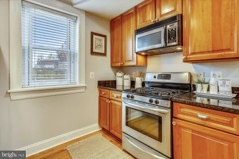 a kitchen with granite countertop cabinets stainless steel appliances and a window