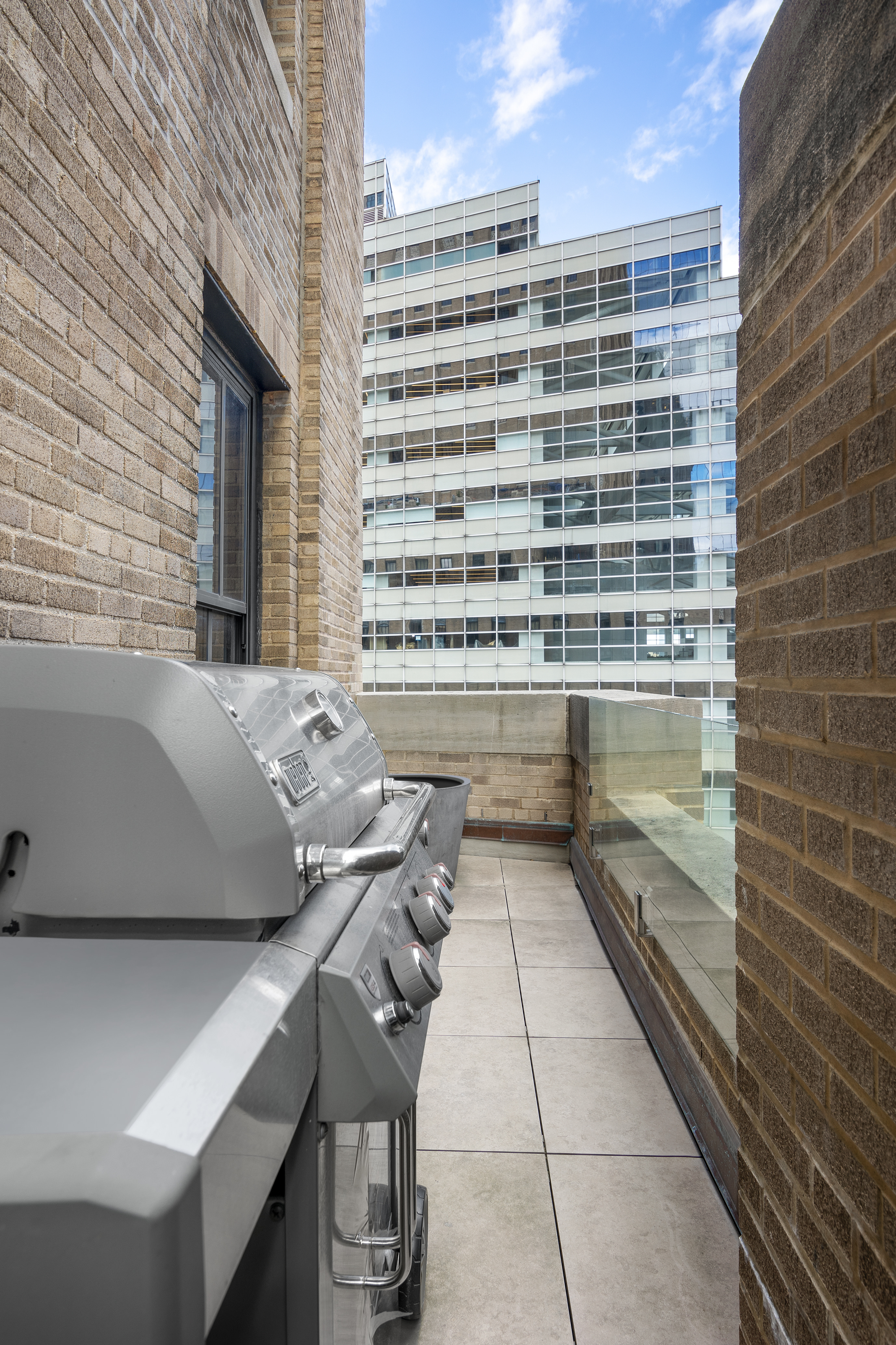 100 Barclay Street, Unit 16D Manhattan, NY 10007 - Photo 5 of 14 a view of balcony with a couple of couches and wooden floor