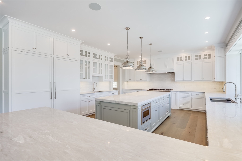 181 Dedham Street Dover, MA 02030 - Photo 6 of 19 a kitchen with a sink stove and white cabinets with wooden floor