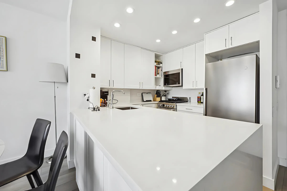 215 West 95th Street, Unit 9J Manhattan, NY 10025 - Photo 2 of 11 a kitchen with kitchen island a stove a sink a refrigerator a microwave and cabinets