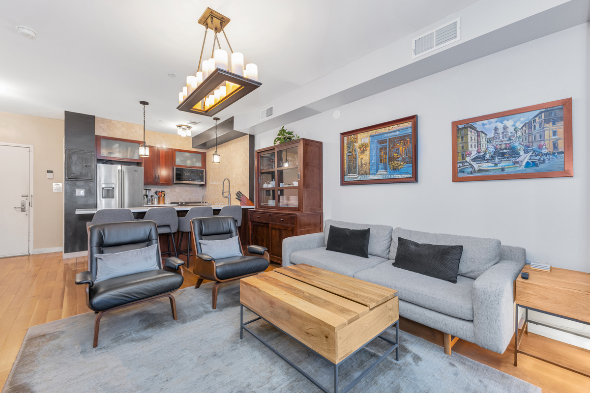 319 Humboldt Street, Unit 1B Brooklyn, NY 11211 - Photo 5 of 17 a living room with furniture a rug and kitchen view