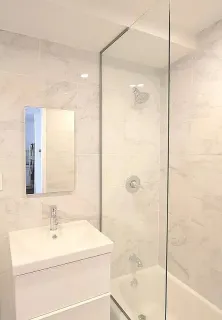 a bathroom with a sink mirror and shower